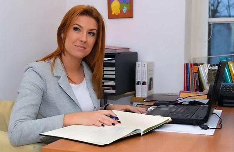 kobieta siedząca za biurkiem z dokumentami